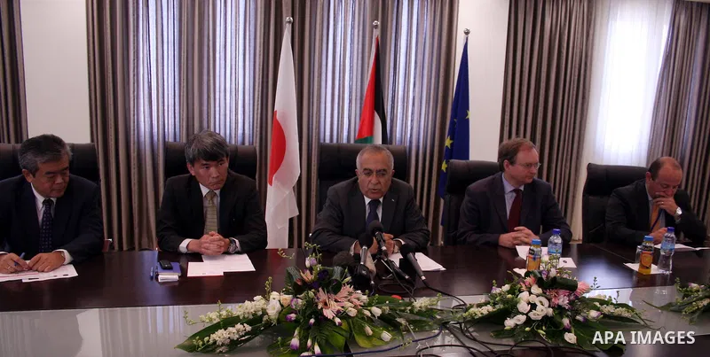 Palestinian Prime Minister Salam Fayyad attend a joint press conference with the Representative of Japan, Naofumi Hashimoto and the EU Representative, Christian Berger during signing an agreement in the West Bank city of...