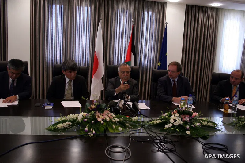 Palestinian Prime Minister Salam Fayyad attend a joint press conference with the Representative of Japan, Naofumi Hashimoto and the EU Representative, Christian Berger during signing an agreement in the West Bank city of...