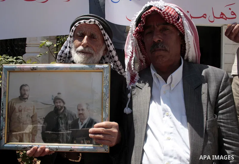 Palestinians hold pictures of their jailed relatives in a protest calling for the release of prisoners from Israeli jails, outside the Red Cross offices in the West Bank city of Hebron on June 01, 2011. Photo by Najeh Ha...