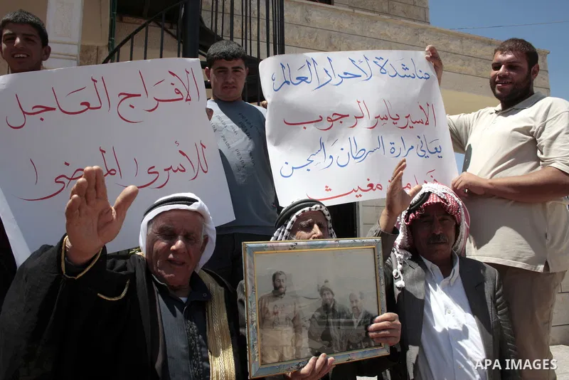 Palestinians hold pictures of their jailed relatives in a protest calling for the release of prisoners from Israeli jails, outside the Red Cross offices in the West Bank city of Hebron on June 01, 2011. Photo by Najeh Ha...