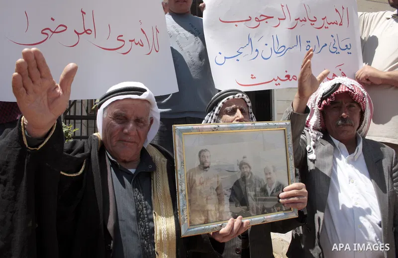Palestinians hold pictures of their jailed relatives in a protest calling for the release of prisoners from Israeli jails, outside the Red Cross offices in the West Bank city of Hebron on June 01, 2011. Photo by Najeh Ha...