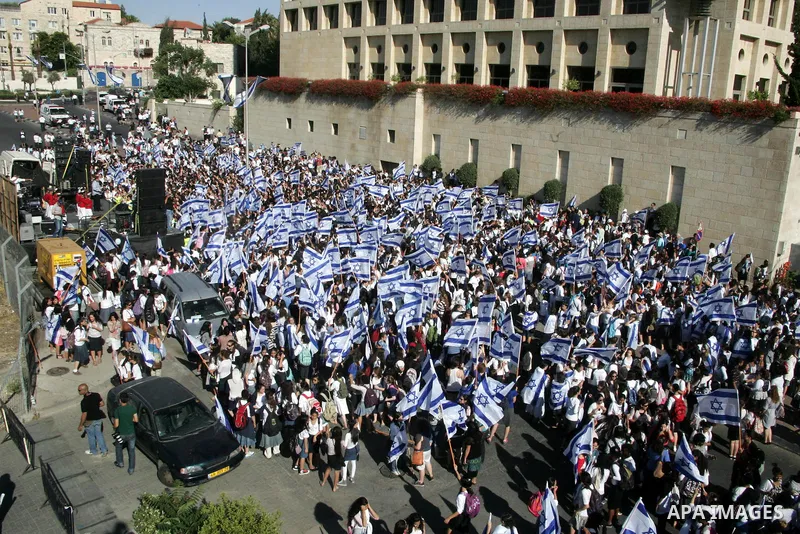 Israelis wave their national flag on July 1, 2011 as some 40,000 Jewish Israelis joined a Jerusalem Day parade in the city's mainly Arab eastern sector to celebrate its capture 44 years ago, during the Six Day War. Photo...