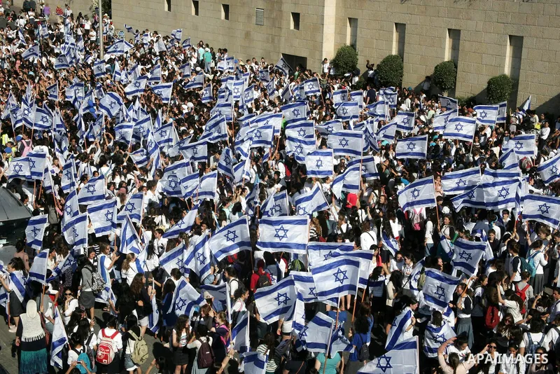 Israelis wave their national flag on July 1, 2011 as some 40,000 Jewish Israelis joined a Jerusalem Day parade in the city's mainly Arab eastern sector to celebrate its capture 44 years ago, during the Six Day War. Photo...