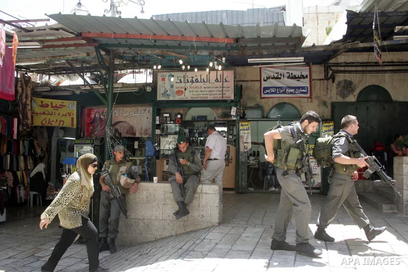 Israeli soldiers guard as Israelis march at Damascus Gate, the main entrance to the old city of Jerusalem, after they started chanting "Death to Arabs" while throwing vegetables, sticks and stones at Palestinian shopkeep...