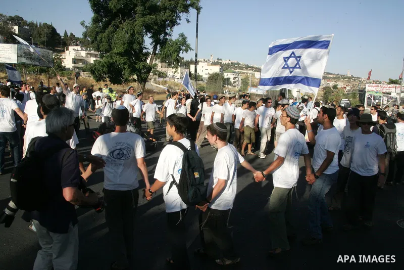 Israelis wave their national flag on July 1, 2011 as some 40,000 Jewish Israelis joined a Jerusalem Day parade in the city's mainly Arab eastern sector to celebrate its capture 44 years ago, during the Six Day War. Photo...