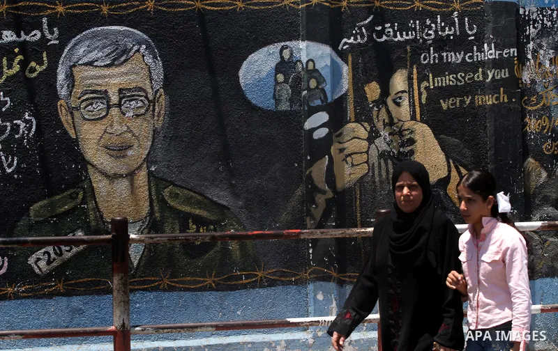 A Palestinian woman walks in front of a mural depicting captured Israeli soldier Gilad Shalit in Gaza City on June 1, 2011. in the release of the captured soldier Versus for a thousand Palestinian prisoners . Said newspa...