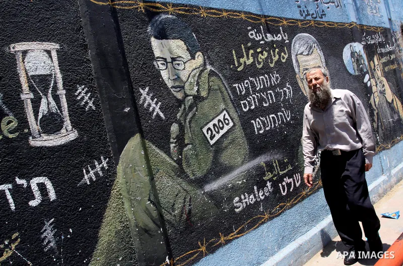 A Palestinian man stands in front of a mural depicting captured Israeli soldier Gilad Shalit in Gaza City on June 1, 2011. in the release of the captured soldier Versus for a thousand Palestinian prisoners . Said newspap...