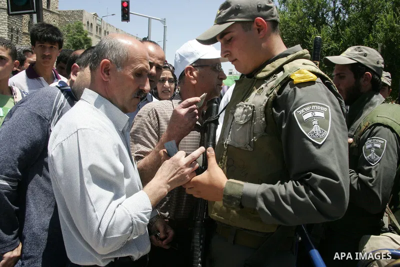 An Israeli soldier checks the identity of A Palestinian Muslim worshiper during Friday prayer in Jerusalem's Old City on June 03, 2011 as Israeli police restricted the entrance age to men over 45 at the Al Aqsa Mosque co...