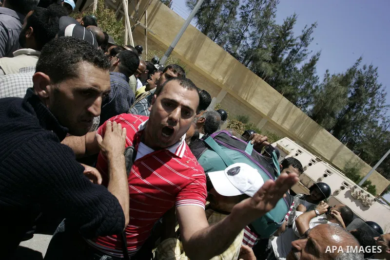 Egyptian security form a line while a Palestinian man shouts wanting to cross into Egypt through the Rafah border crossing on June 4, 2011, as Egyptian officials at the border with Gaza barred Palestinians from crossing,...