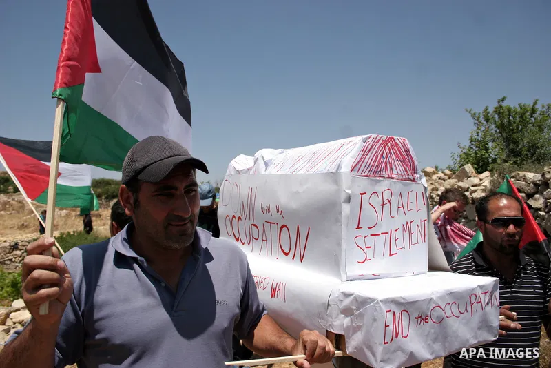 Israeli soldiers stand guard as Palestinians hold up a model of Jewish settlement during a demonstration by foreign, Israeli and Palestinian activists against the Jewish settlement of Karmei Tzur near the Palestinian vil...