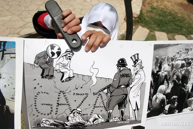 Palestinian Hamas supporters organize a photo gallery for practices of Israeli occupation soldiers and the 44th anniversary of 'Naksa,' Arabic for setback, during a protest in the West Bank city of Hebron on June 05, 201...