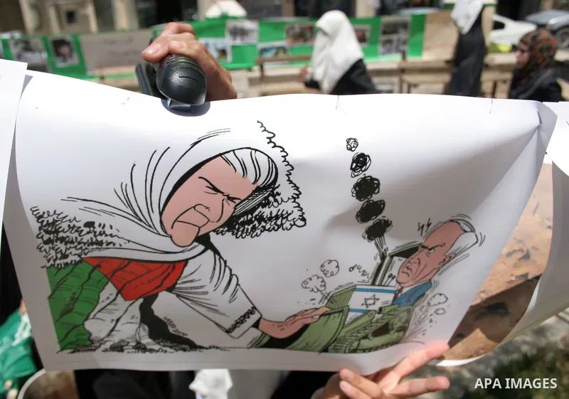 Palestinian Hamas supporters organize a photo gallery for practices of Israeli occupation soldiers and the 44th anniversary of 'Naksa,' Arabic for setback, during a protest in the West Bank city of Hebron on June 05, 201...