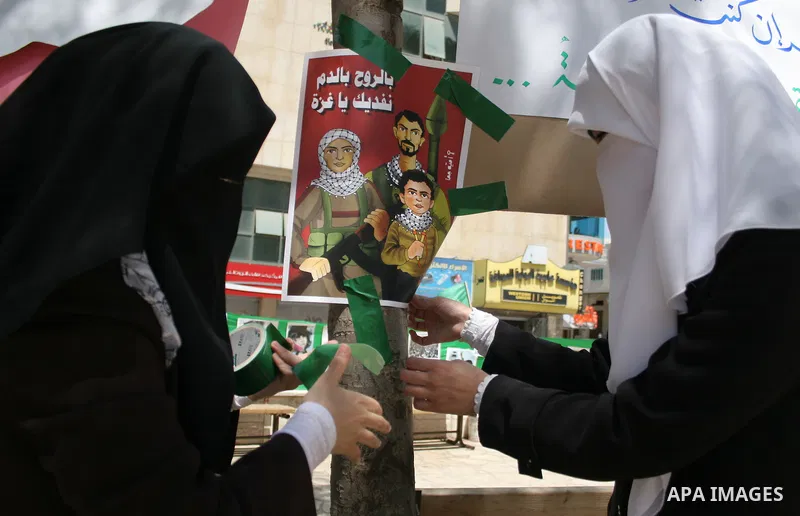 Palestinian Hamas supporters organize a photo gallery for practices of Israeli occupation soldiers and the 44th anniversary of 'Naksa,' Arabic for setback, during a protest in the West Bank city of Hebron on June 05, 201...