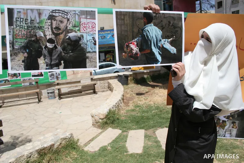 Palestinian Hamas supporters organize a photo gallery for practices of Israeli occupation soldiers and the 44th anniversary of 'Naksa,' Arabic for setback, during a protest in the West Bank city of Hebron on June 05, 201...
