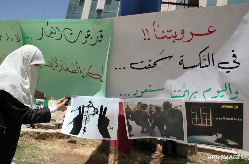 Palestinian Hamas supporters organize a photo gallery for practices of Israeli occupation soldiers and the 44th anniversary of 'Naksa,' Arabic for setback, during a protest in the West Bank city of Hebron on June 05, 201...