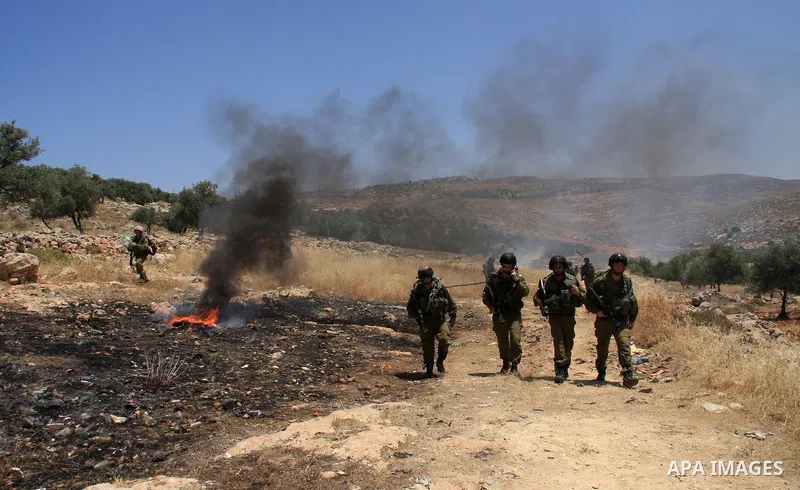 Israeli soldiers stand guard during clashes with Palestinian protestors following a demonstration against Israeli settlements in the West Bank village of Dair al-Hatab, east of Nablus, on June 5, 2011 as Israeli security...