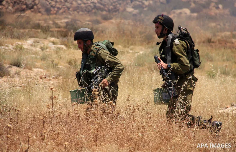 Israeli soldiers stand guard during clashes with Palestinian protestors following a demonstration against Israeli settlements in the West Bank village of Dair al-Hatab, east of Nablus, on June 5, 2011 as Israeli security...