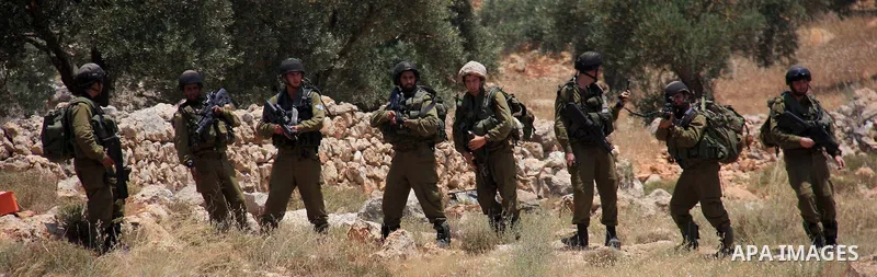 Israeli soldiers stand guard during clashes with Palestinian protestors following a demonstration against Israeli settlements in the West Bank village of Dair al-Hatab, east of Nablus, on June 5, 2011 as Israeli security...