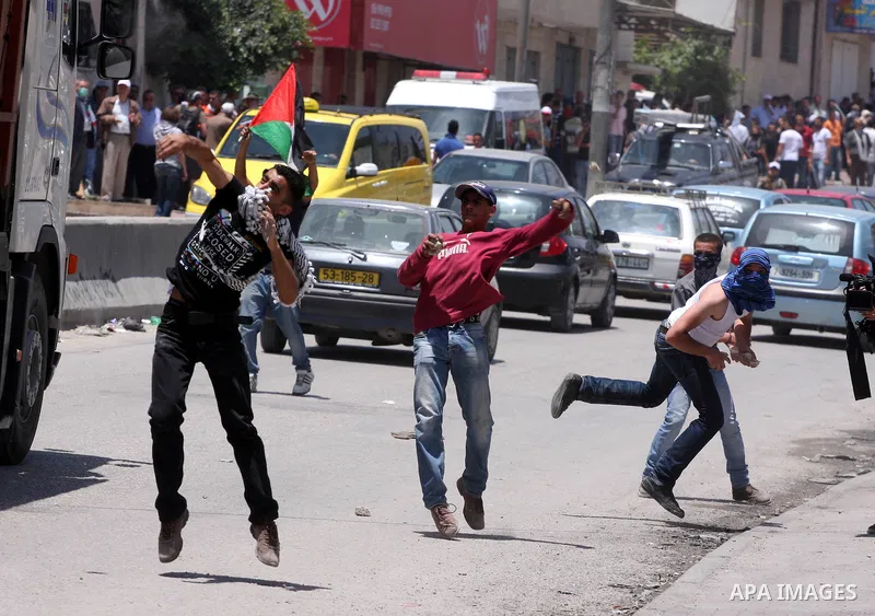 Palestinian demonstrators hurl stones at Israeli soldiers during clashes with Israeli troops at the Qalandia checkpoint, on June 5, 2011 between Jerusalem and the West Bank city of Ramallah. The clashes come on the 44th...