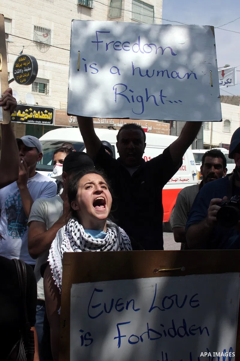 Palestinian demonstrators hold up banners and shout slogans during a protest marking the 44th anniversary of the Six Days War on June 5, 2011 at the Israeli-controlled Qalandia checkpoint between Jerusalem and the West b...