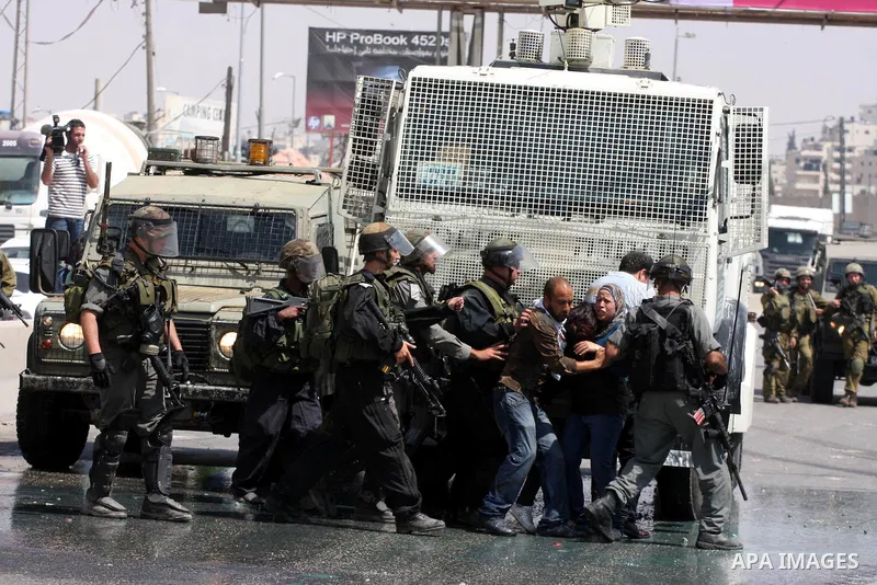 Palestinian demonstrators scuffle with Israeli soldiers during a protest marking the 44th anniversary of the Six Days War on June 5, 2011 at the Israeli-controlled Qalandia checkpoint between Jerusalem and the West bank...
