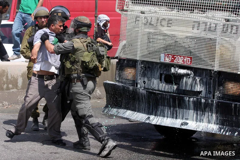A Palestinian demonstrator scuffles with Israeli soldiers during a protest marking the 44th anniversary of the Six Days War on June 5, 2011 at the Israeli-controlled Qalandia checkpoint between Jerusalem and the West ban...