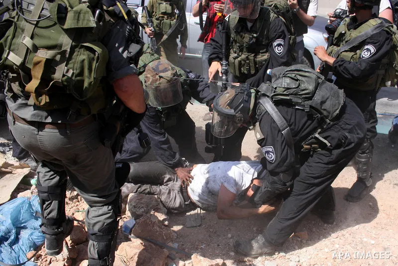 A Palestinian demonstrator scuffles with Israeli soldiers during a protest marking the 44th anniversary of the Six Days War on June 5, 2011 at the Israeli-controlled Qalandia checkpoint between Jerusalem and the West ban...