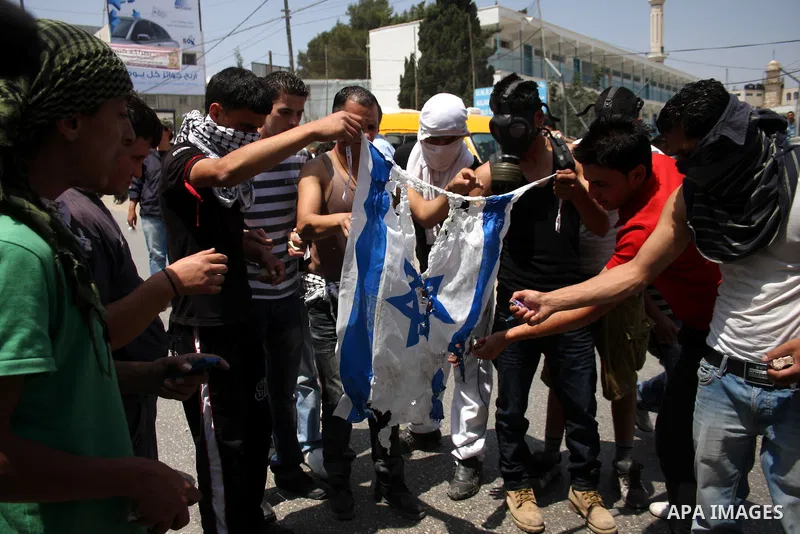 Palestinian demonstrators burn an Israeli flag during clashes with Israeli troops at the Qalandia checkpoint, on June 5, 2011 between Jerusalem and the West Bank city of Ramallah. The clashes come on the 44th anniversary...