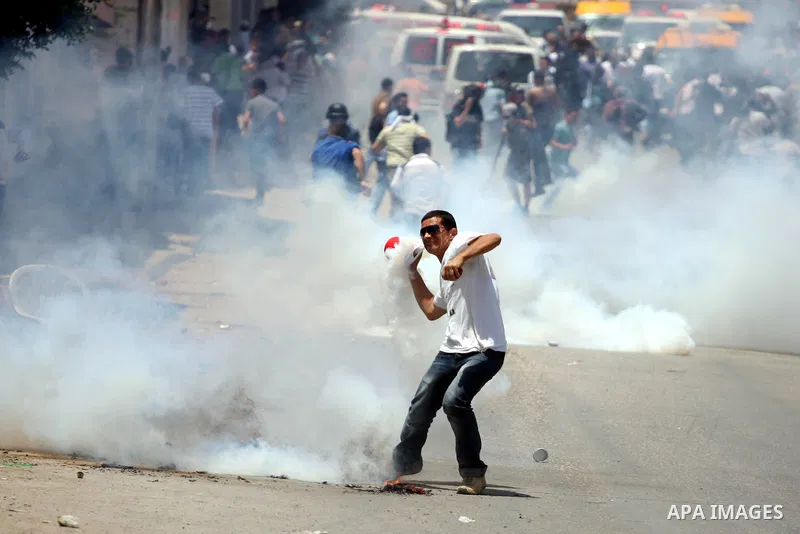 Palestinian demonstrators run for cover from tear gas canisters fired by Israeli soldiers during a protest marking the 44th anniversary of the Six Days War on June 5, 2011 at the Israeli-controlled Qalandia checkpoint be...