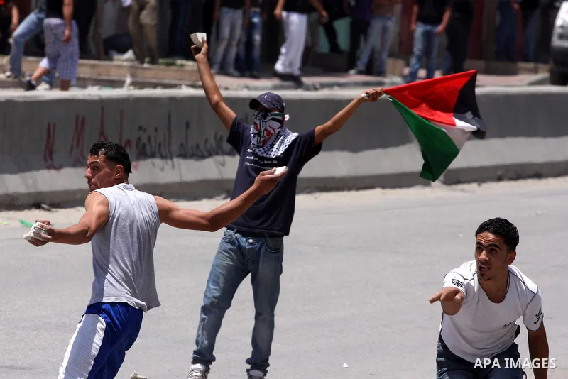 Palestinian demonstrators hurl stones at Israeli soldiers during clashes with Israeli troops at the Qalandia checkpoint, on June 5, 2011 between Jerusalem and the West Bank city of Ramallah. The clashes come on the 44th...