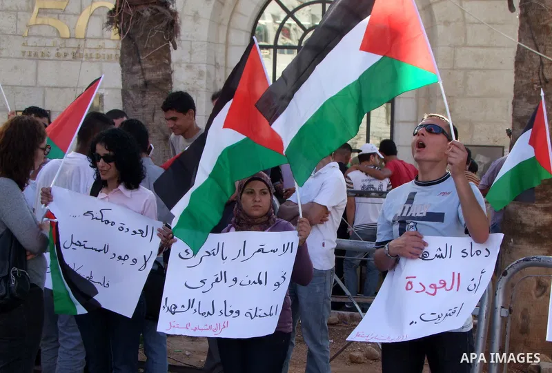 Palestinians shout slogans and hold their national flag as they demonstrate in the West Bank city of Ramallah on June 6, 2011 in respect to those who were killed a day earlier by Israeli soldiers during a protest marking...
