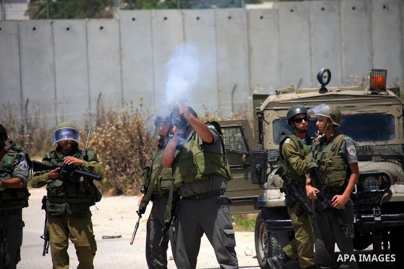 Israeli soldiers fire tear gas canisters during clashes with Palestinians following a protest against Israel's separation barrier in the village Nazlet Issa north Tulkarm in the West Bank on June 7, 2011. Photo by Wagdi...