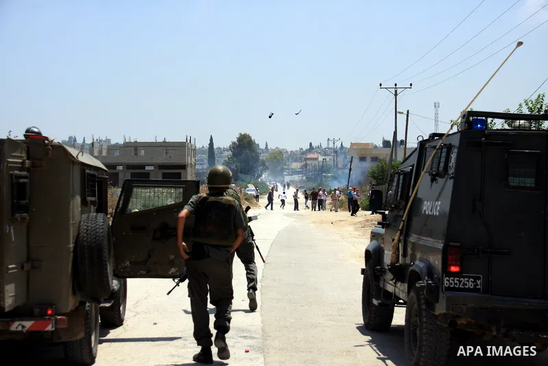 Israeli soldiers fire tear gas canisters during clashes following a protest against Israel's separation barrier in the village Nazlet Issa north Tulkarm in the West Bank on June 7, 2011. Photo by Wagdi Eshtayah