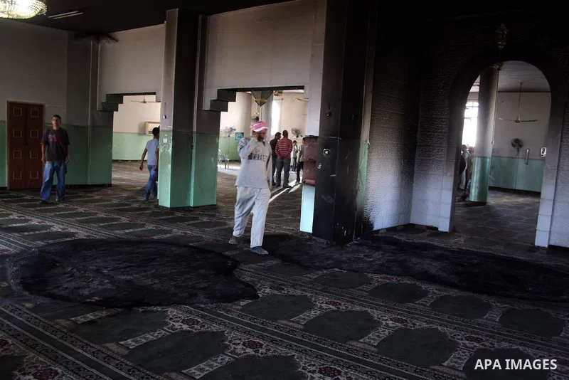 A Palestinian man inspects a partially burn mosque in the West Bank of al-Mughayyir village, some 20 kilometres (12 miles) northeast of Ramallah City on June 7, 2011. Palestinian security sources said Jewish settlers are...