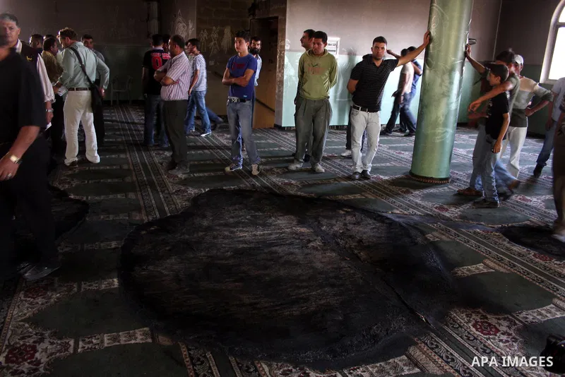 A Palestinian man inspects a partially burn mosque in the West Bank of al-Mughayyir village, some 20 kilometres (12 miles) northeast of Ramallah City on June 7, 2011. Palestinian security sources said Jewish settlers are...
