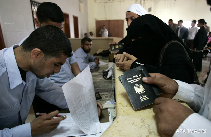 Palestinians border police check documents of travellers waiting to cross into Egypt through the Rafah border crossing in the southern Gaza Strip on June 8, 2011 after it was reopened, ending a four-day closure amid disa...