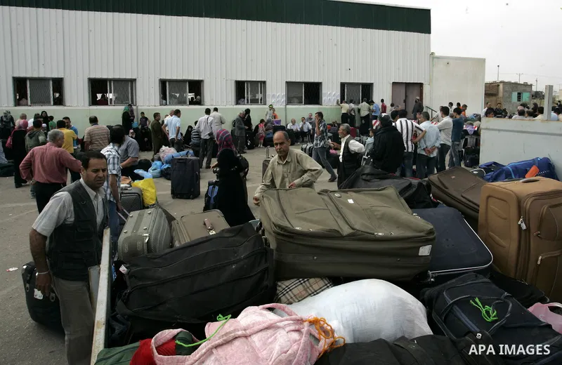 Palestinians load their luggage and wait to cross into Egypt through the Rafah border crossing in the southern Gaza Strip on June 8, 2011 after it was reopened, ending a four-day closure amid disagreements between Egypti...