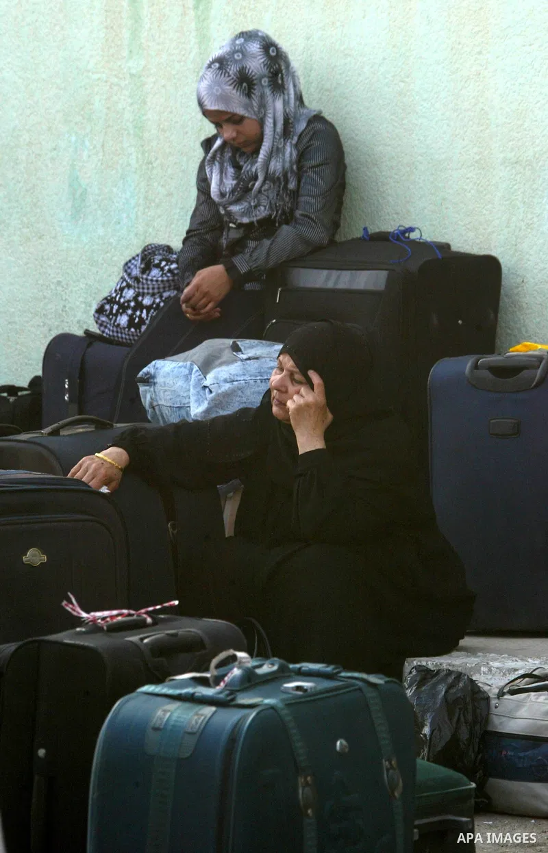 Palestinian women wait to cross into Egypt through the Rafah border crossing in the southern Gaza Strip on June 8, 2011 after it was reopened, ending a four-day closure amid disagreements between Egyptian and Hamas offic...