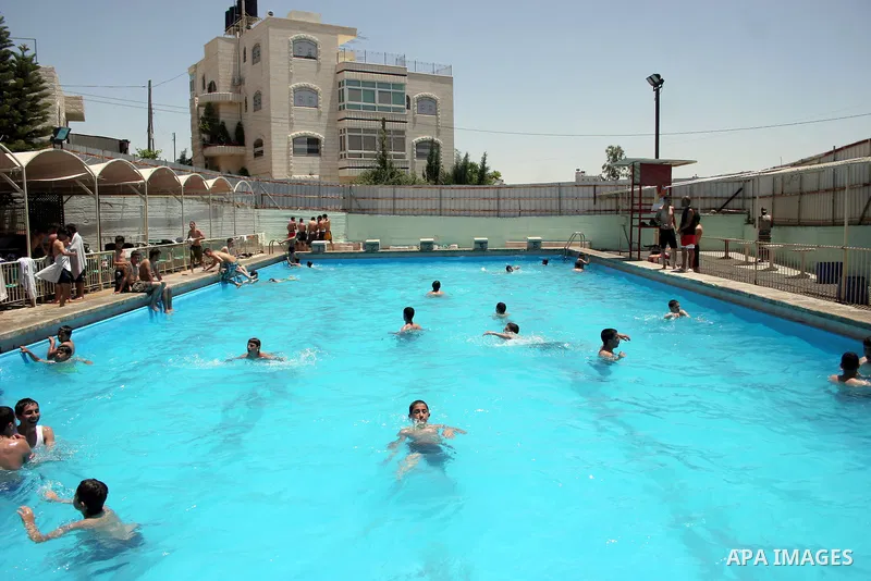 Palestinian boys and girls enjoy swimming in the swimming pool to feel relaxation after completion of their school examinations and the end of schools year, in the West Bank city of Hebron on June 08,2011.Photo by Najeh...