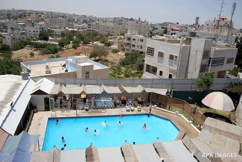 Palestinian boys and girls enjoy swimming in the swimming pool to feel relaxation after completion of their school examinations and the end of schools year, in the West Bank city of Hebron on June 08,2011. Photo by Najeh...