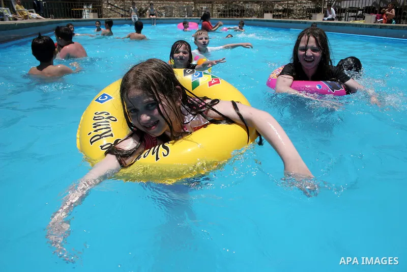 Palestinian girls and boys enjoy swimming in the swimming pool to feel relaxation after completion of their school examinations and the end of schools year, in the West Bank city of Hebron on June 08,2011. Photo by Najeh...