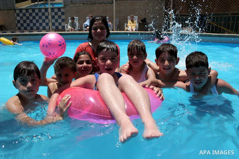 Palestinian girls and boys enjoy swimming in the swimming pool to feel relaxation after completion of their school examinations and the end of schools year, in the West Bank city of Hebron on June 08,2011. Photo by Najeh...