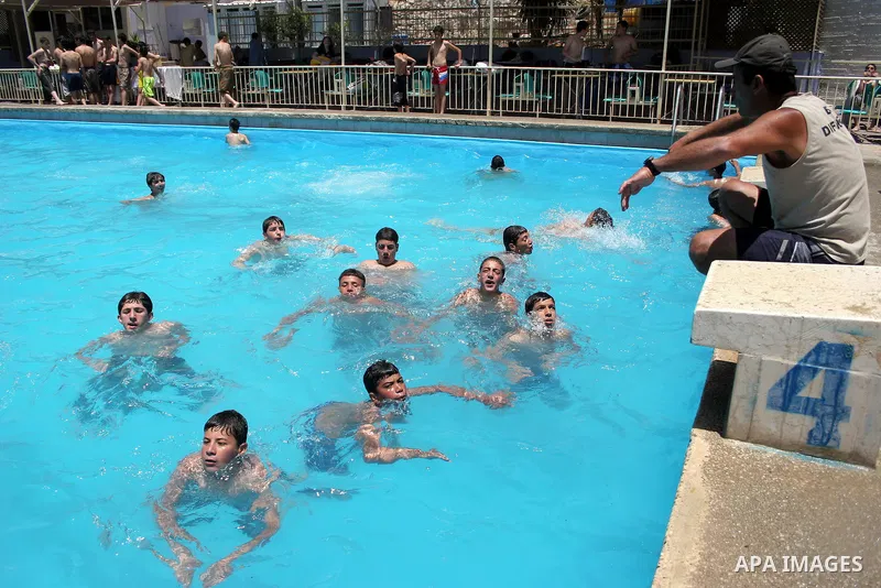 Palestinian girls and boys enjoy swimming in the swimming pool to feel relaxation after completion of their school examinations and the end of schools year, in the West Bank city of Hebron on June 08,2011. Photo by Najeh...