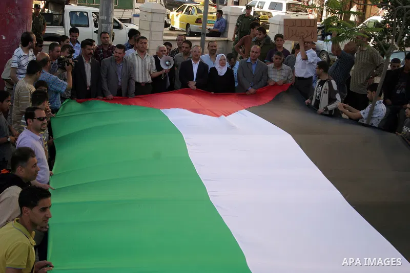 Palestinians hold up Palestinian National flag during a protest to mark the 44th anniversary of 'Naksa,' Arabic for setback, in the West Bank city of Hebron on June 09, 2011, as Palestinian activists in Jerusalem, the We...