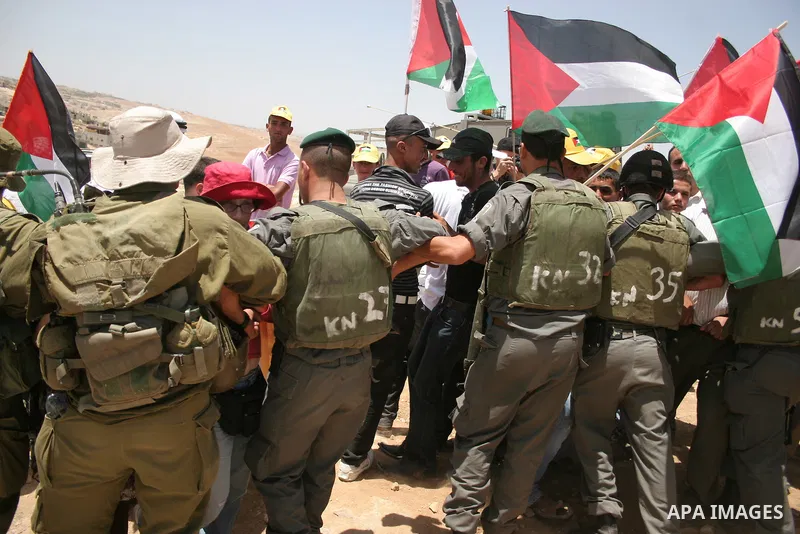 Israeli forces disperse a demonstration by Palestinian and foreign peace activists against Israeli settlements in the West Bank village of Al-Tuwani, near Hebron, on June 10,2011. Photo by Najeh Hashlamoun .