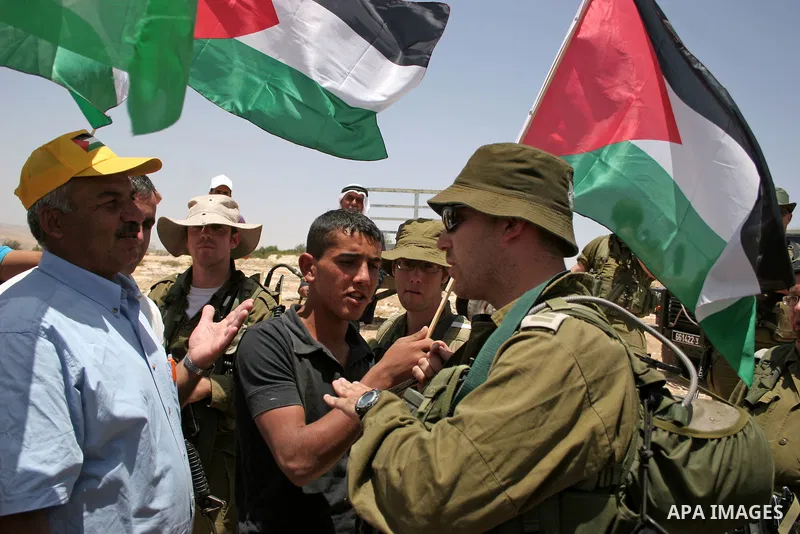 Israeli forces disperse a demonstration by Palestinian and foreign peace activists against Israeli settlements in the West Bank village of Al-Tuwani, near Hebron, on June 10,2011. Photo by Najeh Hashlamoun .