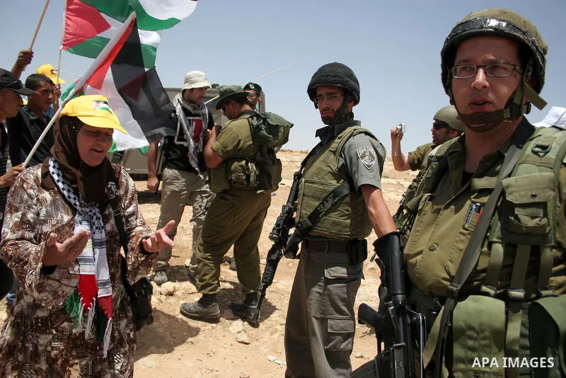 Israeli forces disperse a demonstration by Palestinian and foreign peace activists against Israeli settlements in the West Bank village of Al-Tuwani, near Hebron, on June 10,2011. Photo by Najeh Hashlamoun .