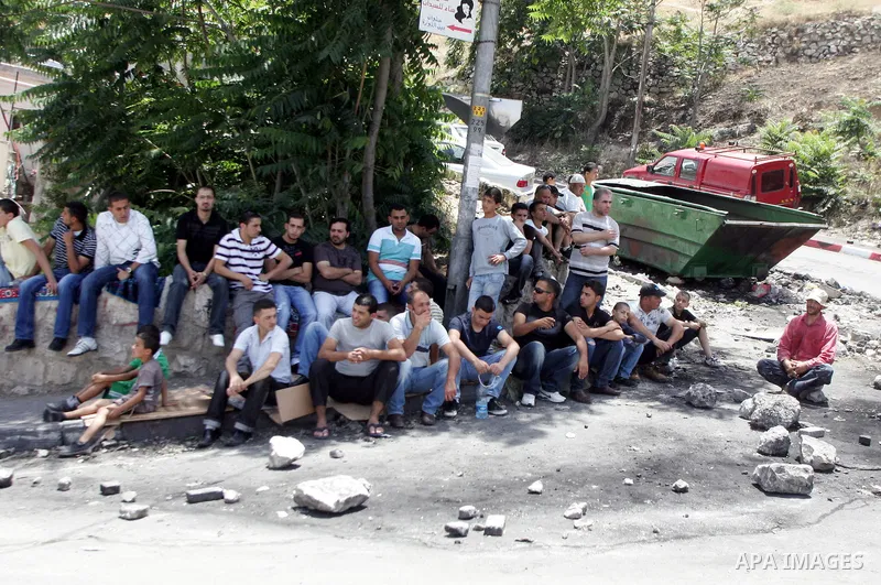 Palestinian youths prepare to hurl stones at Israeli forces after Friday prayers near a protest tent in the mostly Arab neighbourhood of Silwan in east Jerusalem on June 10, 2011. Photo by Mahfouz Abu Turk
