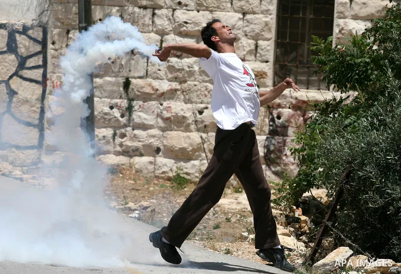 A demonstrator throws back a tear gas canister fired by Israeli forces during clashes following a protest against the expropriation of Palestinian land, in the village of Nabi Saleh, in the Israeli-occupied West Bank, on...