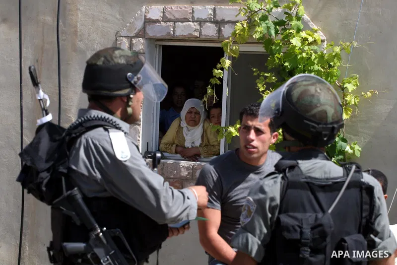 Palestinians look at Israeli forces during clashes following a protest against the expropriation of Palestinian land, in the village of Nabi Saleh, in the Israeli-occupied West Bank, on June 10, 2011. Photo by Issam Rima...